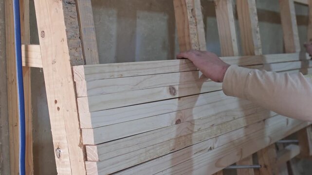 Carpenter stacking planks to laminate
