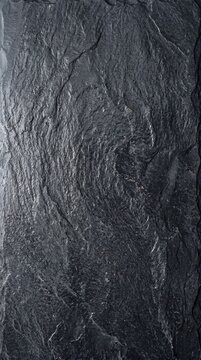 Natural dark grey slate stone texture with a rough uneven surface and subtle highlights