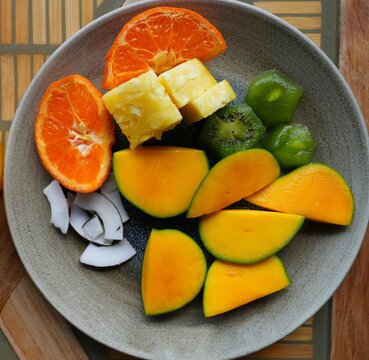 View of a healthy tropical fruit platter with pineapple, clementine, kiwi, and mango