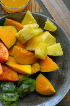 View of a healthy tropical fruit platter with pineapple, clementine, kiwi, and mango