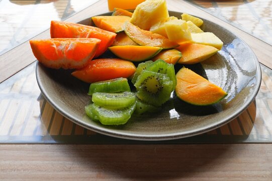 View of a healthy tropical fruit platter with pineapple, clementine, kiwi, and mango