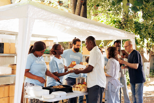Multiethnic group of individuals collaborate at charity center, organizing a food drive to support the poor and needy, with selfless actions of volunteers provides hunger relief and humanitarian aid.