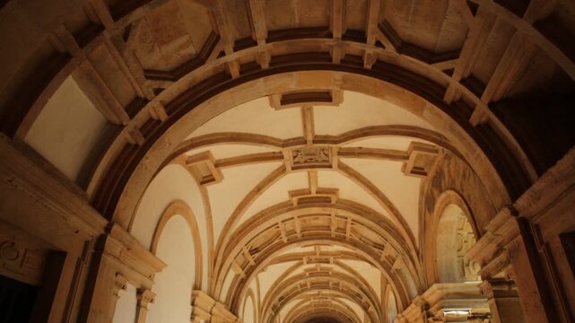 Tomar, Portugal - August 10, 2017: corridor and decorated ceiling inside small Claustro de Santa Barbara in Templar Castle of Tomar or Convent of Christ. Unesco Heritage and popular place.
