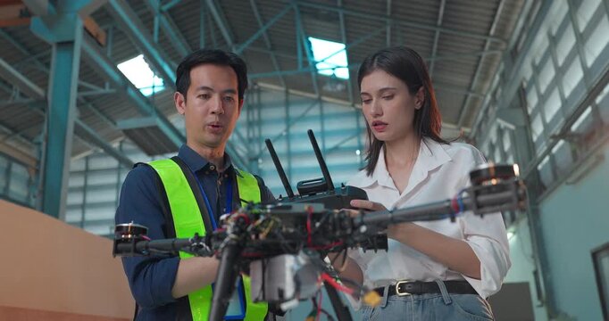 Startup Entrepreneur and Engineer Review Drone Prototype in Industrial Workshop