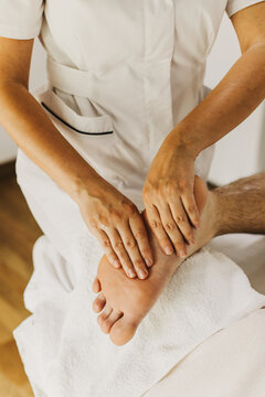 Close up of foot massage therapy session. Female massage therapist's hands.