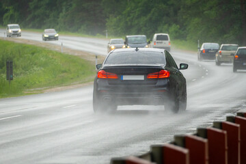 Obraz premium Heavy Traffic on Curved Highway During Rainstorm with Reduced Visibility and Wet Road Conditions