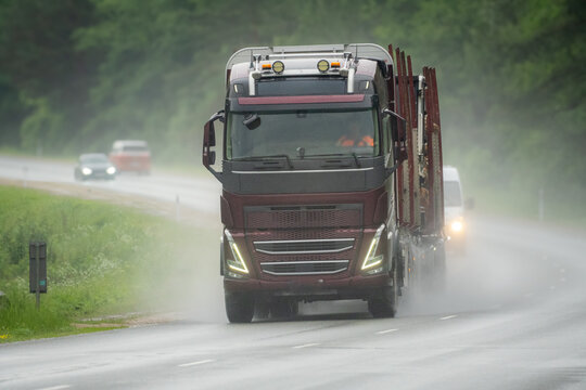 Heavy Timber Truck Driving on Wet Highway During Rain and Poor Visibility