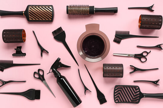 Professional hairdressing tools and hair dye bowl on pink background, salon equipment for hair styling and coloring