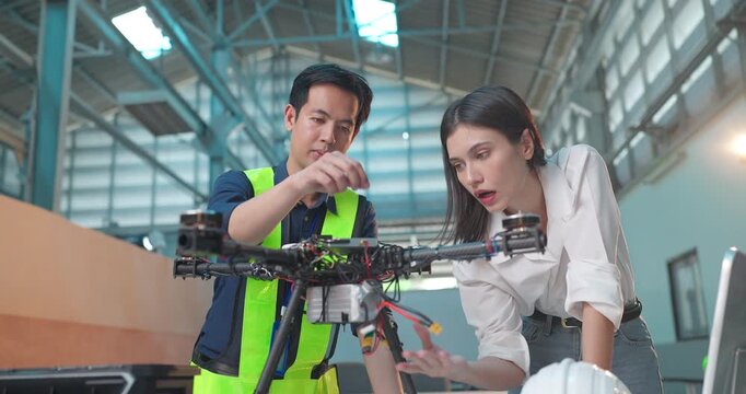 Startup Entrepreneur and Engineer Review Drone Prototype in Industrial Workshop