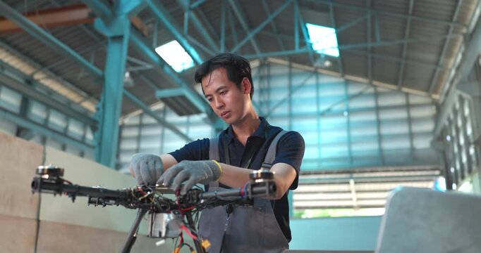 Male Engineer Review Drone Prototype in Industrial Workshop