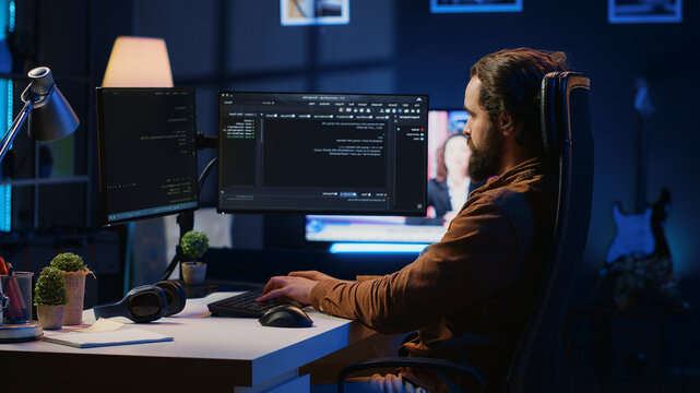 Experienced programmer writing code on computer screen while in office using java programming languages. Developer working on fixing database errors while working from home, camera A.