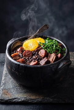 Traditional Brazilian Feijoada Stew with Black Beans and Meat in Clay Pot