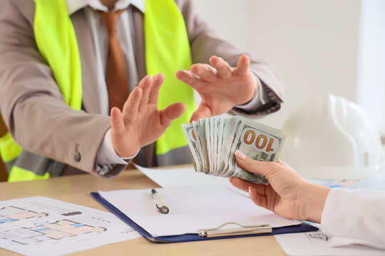 Construction worker refusing bribe money, anti-corruption and ethical business practices in engineering and building industry
