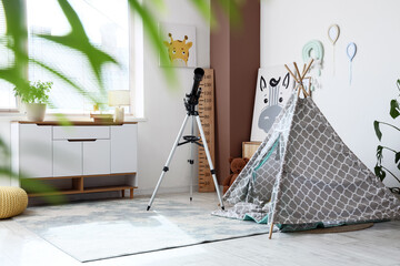 Modern childrens playroom interior with teepee tent, telescope, and stylish furniture for creative learning and fun © Pixel-Shot
