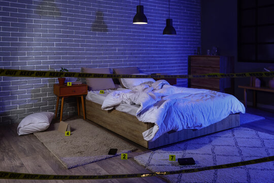 Crime scene investigation in a dark bedroom with evidence markers and police tape