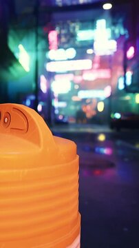 An orange object is seen close up in a city street at night. Colorful neon signs illuminate the background. The atmosphere shows a busy urban setting with bright lights.