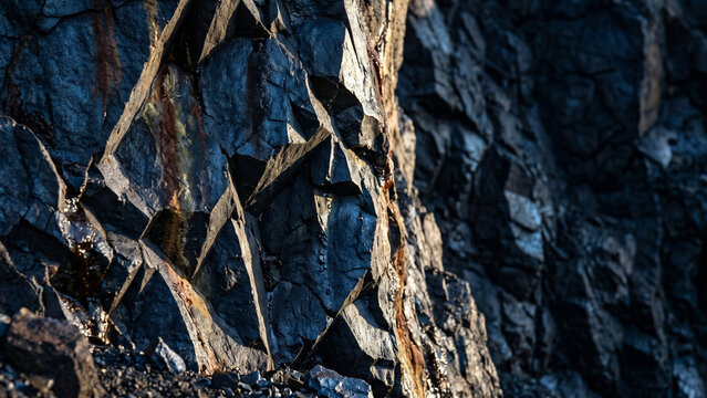 Manganese ore cliff face, dark blues