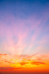 Fototapeta premium Sky sunset,Beautiful sunrise sky with vibrant gradient orange and gold colors and soft blue, Clear atmosphere with wispy clouds. Peaceful, perfect for background and copy space, vertical