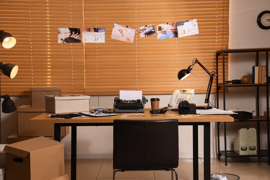 Detectives office desk with crime scene photos, typewriter, and investigation tools for solving cases