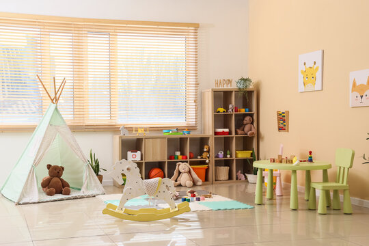 Bright childrens playroom interior with teepee, rocking horse, and toy storage for early childhood development