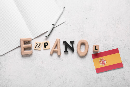 Spanish language learning with "espanol" letters, spain flag, notebook, and pen on white background