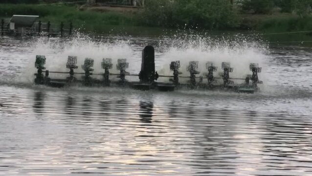Water aerator machine in pond creating splashes and ripples for aquaculture