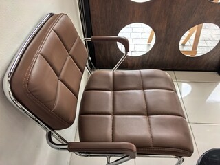Naklejka premium Modern brown leatherette chairs with chrome frames in a stylish interior setting