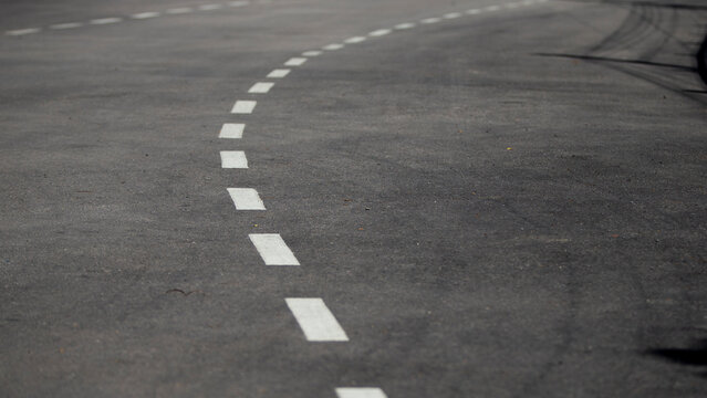 Asphalt road with white markings. Abstract background for design and decoration.