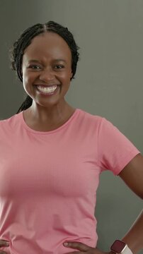 Vertical video: Glancing at wrist, woman in pink tee adjusting smartwatch band at home for fitness