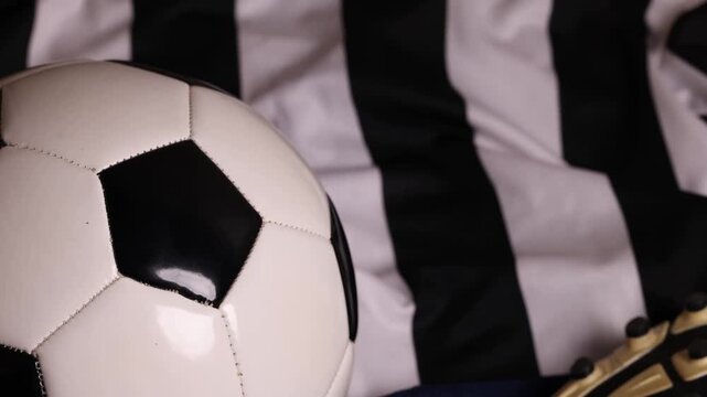 soccer ball and cleats on striped jersey (association football kit with shorts and boots) sports player gear competition playing play goal scoring