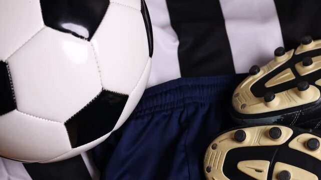 soccer ball and cleats on striped jersey (association football kit with shorts and boots) sports player gear competition playing play goal scoring