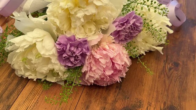 Romantic bouquet of peonies and carnations on rustic table, evoking tenderness, gratitude and heartfelt moments for weddings, anniversaries and celebrations