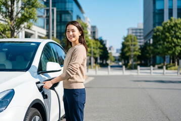 Fototapeta premium 電気自動車を充電スタンドで充電する笑顔の女性 Generative AI