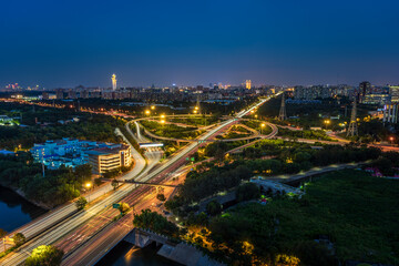 Fototapeta premium The bustling traffic lights and cityscape skyline of Qingqiao Bridge in Beijing at night.