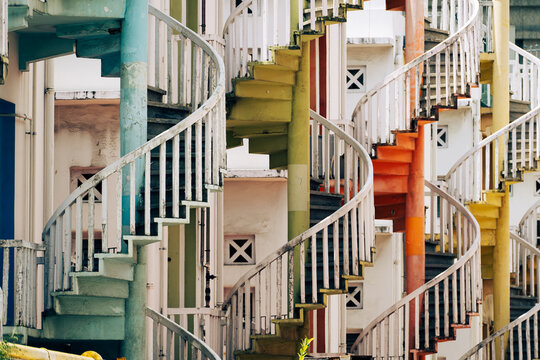 Iconic pastel spiral staircases in Bugis, Singapore, forming a striking geometric pattern against colonial-style shophouses.