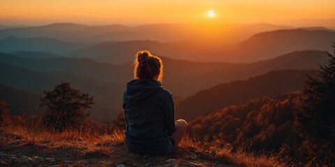 Obraz premium Beautiful Sunset Over Hills with Silhouette of Woman Embracing Nature and Fresh Air in Peaceful Landscape