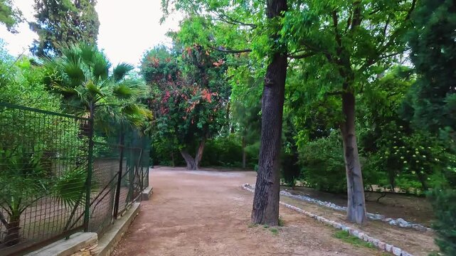 Attica Zoological Park in Athens, Greece with fence enclosure for exotic tropical birds captive wildlife point of view walking on trail footpath