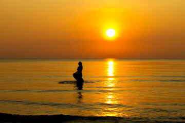 Fototapeta premium Woman with sunrise and silhouette