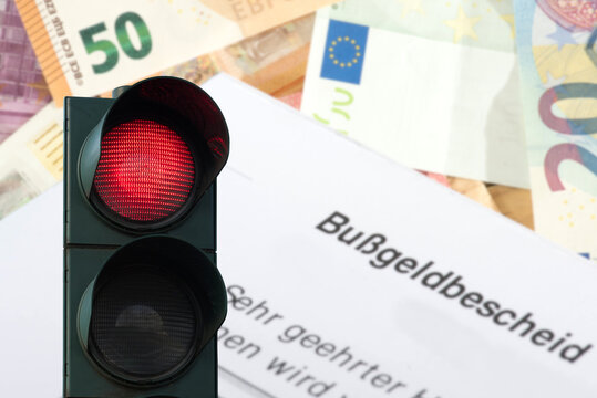 Euro Geldscheine, Bu&szlig;geldbescheid und eine rote Ampel als Symbol f&uuml;r Rotlichversto&szlig; im Stra&szlig;enverkehr