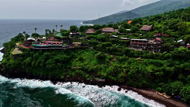 Coastline in Amed, Bali, Indonesia with ocean waves crashing in aerial approaching view