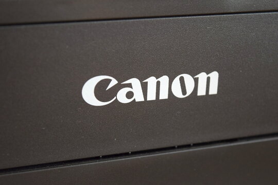 White Canon corporate logo on a black plastic printer body