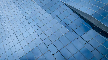 Fototapeta premium Modern glass facade of a tall skyscraper building with abstract geometric architectural details in Vienna Austria corporate business district