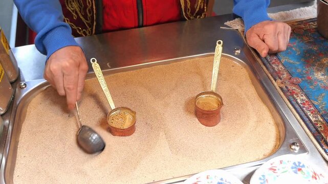 preparation of Turkish coffee using a specialized sand heater to evenly distribute heat