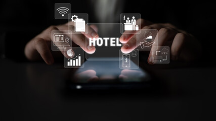 Businessman using smartphone for hotel management apps with digital interface icons for booking,...