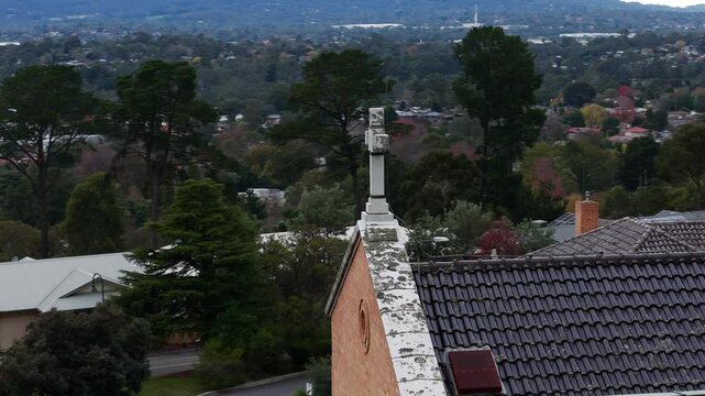 Aerial view of a church roof with suburbs in the background