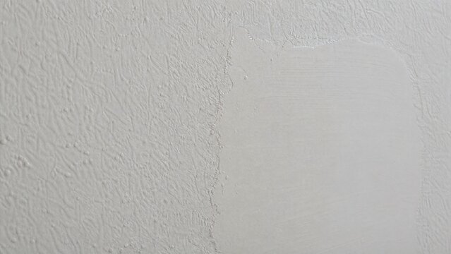 Close-up of a repaired wall showing texture difference between old and new patch.