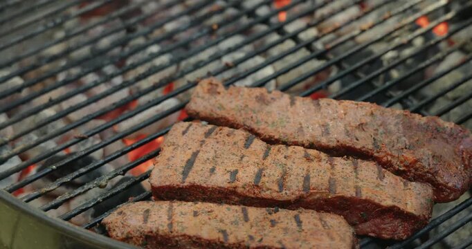 Marinated beef steaks cooking on a charcoal grill