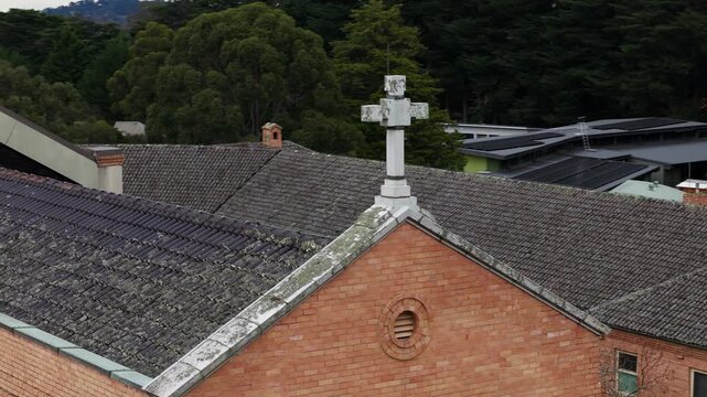 Descending aerial shot of a large brick church with two crosses