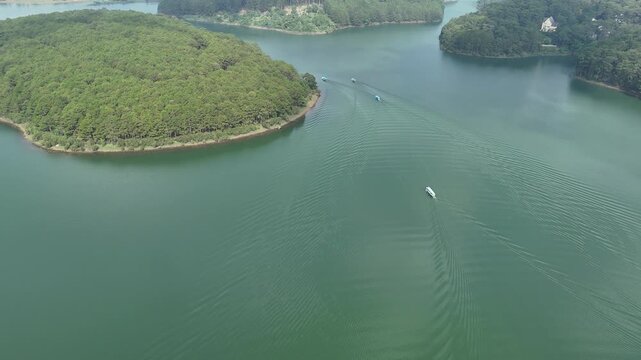 Descending Drone Shot Following Tourist Boat on Tuyen Lam Lake in Da Lat, Vietnam