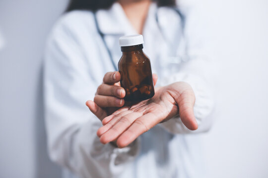 The pharmacist or doctor holding medication or medicine for treatment. Anti biotic pill in the vial.